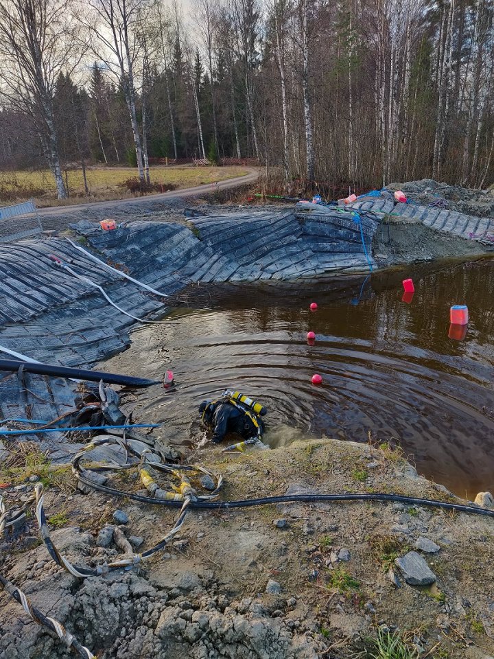 Marraskuu: Sukeltaja asentaa urakkarajalla laippoja putkien päähän pikkupakkasesta huolimatta, jotta viimeisiinkin putkiin päästäisiin tekemään painekokeet.