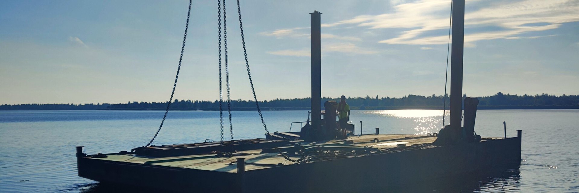 Työlauttaa lasketaan vesille nostoketjuissa, tukijalat pystyssä