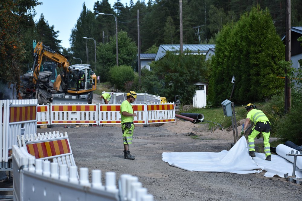 Vesihuoltoverkoston saneeraus asutulla kadulla, työmaa aidattuna ja liikenne ohjattuna